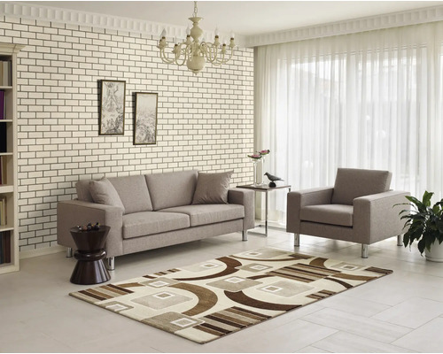 Wohnzimmer mit Sofa, Sessel und geometrischem Teppich