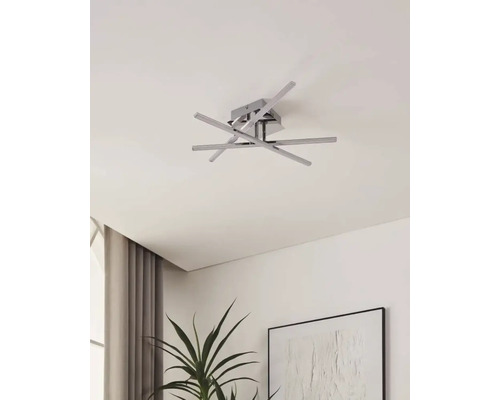 Plafonnier moderne avec plusieurs bras et une base carrée sur un plafond de pièce.