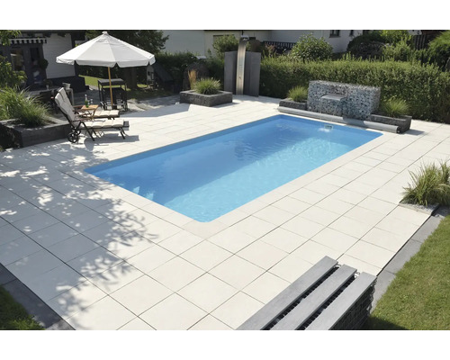 Piscine dans le jardin avec sol en dalles de pierre, mur en gabions et douche extérieure
