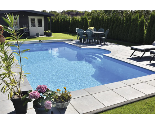 Piscine dans le jardin avec terrasse, abri de jardin, table et chaises