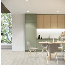 Cuisine claire avec table à manger et chaises, combinée à des meubles de cuisine aspect bois et vert.