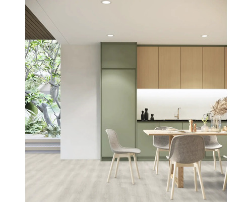 Cuisine claire avec table à manger et chaises, combinée à des meubles de cuisine aspect bois et vert.