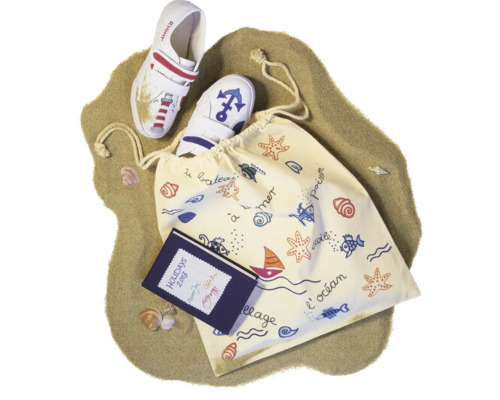 Charentaises pour enfants avec sac de marin et carnet sur le sable