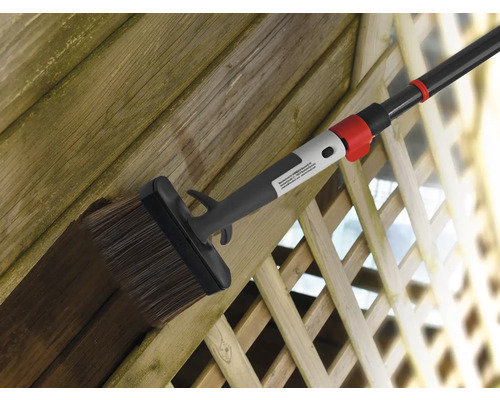Holzzaun wird mit Flächenstreicher und Teleskopstiel gestrichen