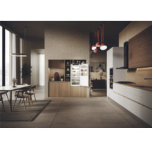 Cuisine lumineuse avec réfrigérateur ouvert, coin repas et mobilier moderne.