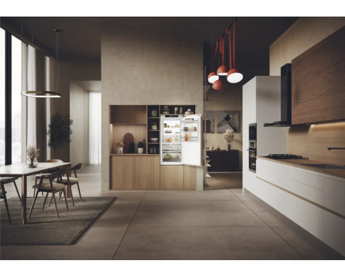 Helle Küche mit offenem Kühlschrank, Essbereich und modernen Möbeln.