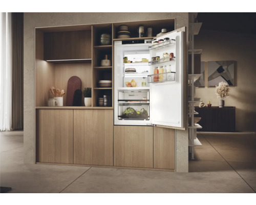 Integrierter Kühlschrank mit offener Tür in heller Einbauküche.