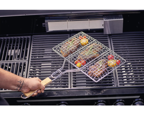 Viande et légumes dans un panier à griller sur un barbecue