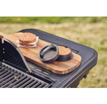 Burgerpresse mit zwei Fleisch-Burgern auf einem Grilltisch