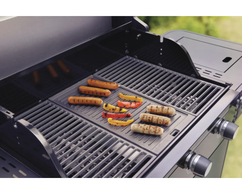 Gasgrill mit Würstchen und Paprika auf dem Grillrost.