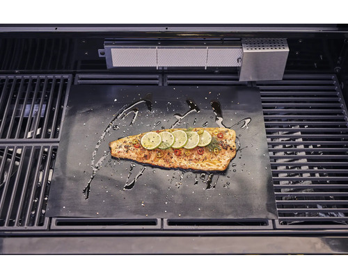 Lachs auf Grillmatte mit Zitronenscheiben und Gewürzen im Grill.