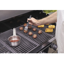 Fleischbällchen und Maiskolben werden auf einem Grill zubereitet.