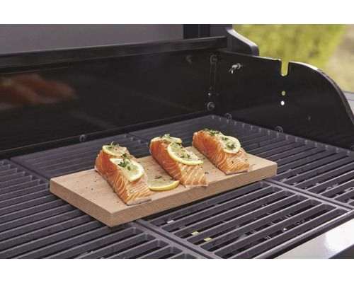 Drei Lachsfilets mit Zitrone auf einem Holzbrett auf einem Grill