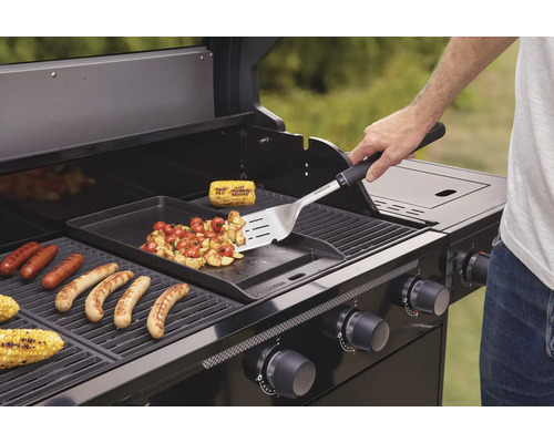 Person grillt Würstchen, Mais und Gemüse auf einem Gasgrill.