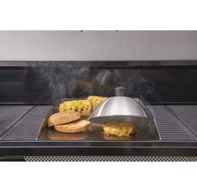 Grillszene mit Burger, Maiskolben und Grillglocke auf Grillplatte