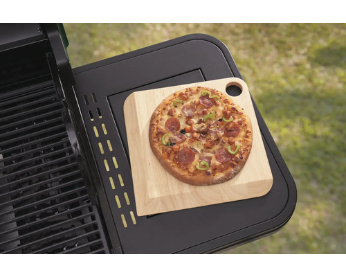 Pizza auf Holzbrett auf einem Grilltisch