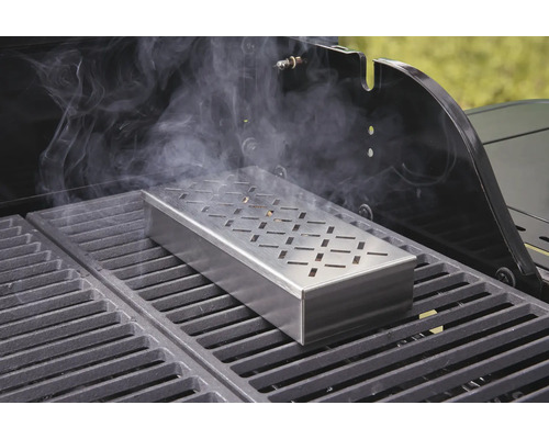 Boîte à fumer sur un barbecue avec dégagement de fumée.