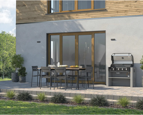 Espace extérieur avec barbecue de jardin, table à manger et chaises devant une maison