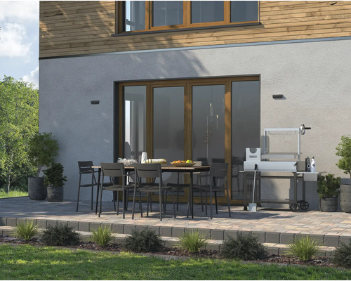 Extérieur avec table à manger, chaises et barbecue devant une maison