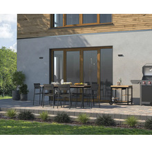 Terrasse avec table à manger, chaises, barbecue et chariot de barbecue devant une maison