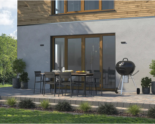 Terrasse avec barbecue, table de jardin et chaises devant une maison