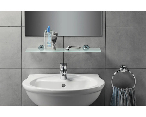 Lavabo de salle de bain avec robinet, étagère en verre, anneau porte-serviettes et miroir sur des carreaux gris