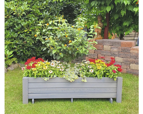 Jardinière en bois avec des fleurs dans le jardin.