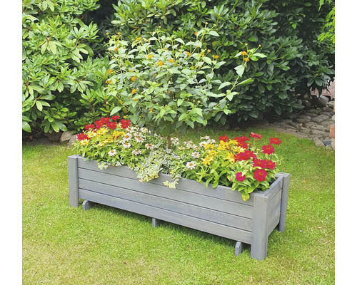 Jardinière en bois avec diverses fleurs dans le jardin.