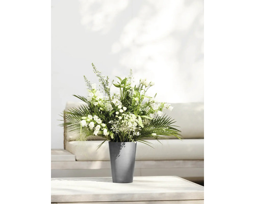 Blumenstrauß mit weißen Blüten in einem grauen Topf auf einem Tisch