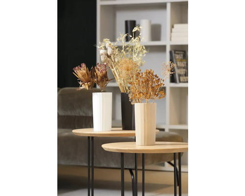 Fleurs séchées décoratives dans des vases sur des tables d''appoint dans un salon.