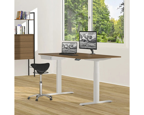 Bureau réglable en hauteur avec ordinateurs, tabouret assis-debout et bibliothèque dans une pièce lumineuse.