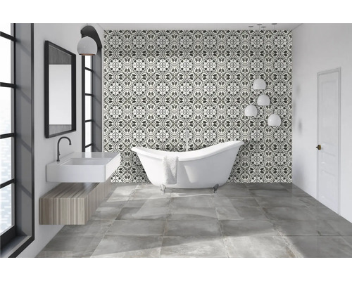 Badezimmer mit freistehender Badewanne, Waschbecken und gemusterten Fliesen