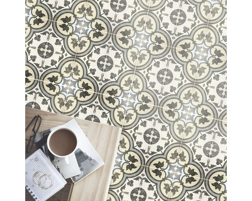 Verlegtes Fliesenmuster mit floralem Dekor und Gebrauchsgegenständen auf einem Holztisch