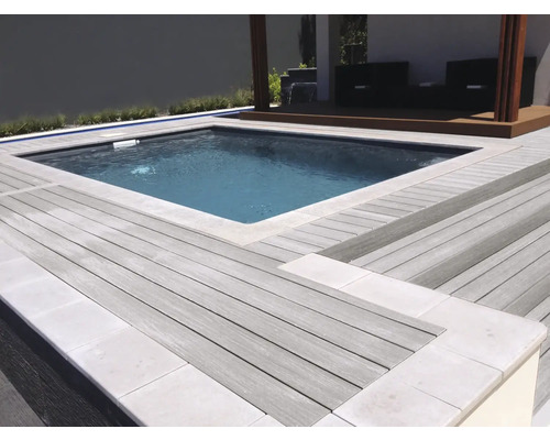 Swimmingpool umgeben von einer Holzterrasse mit Sitzbereich