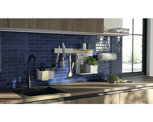 Scène de cuisine avec évier, robinet, mur carrelé et ustensiles de cuisine