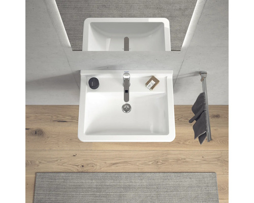 Lavabo de salle de bain avec robinet, serviette et savon vus de dessus.