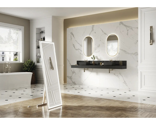 Salle de bains lumineuse avec baignoire, lavabos avec miroirs et miroir sur pied