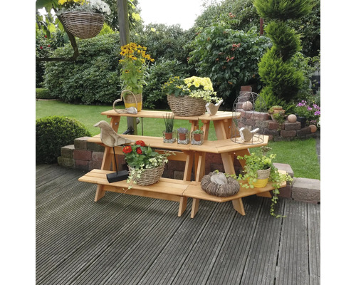 Mehrstufiges Pflanzenregal aus Holz im Garten mit Blumen und Dekorationen.