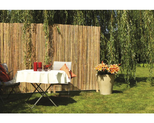 Brise-vue en bambou avec table de jardin et décoration dans le jardin