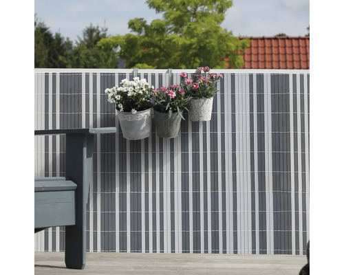 Sichtschutzzaun mit Blumenampeln im Garten