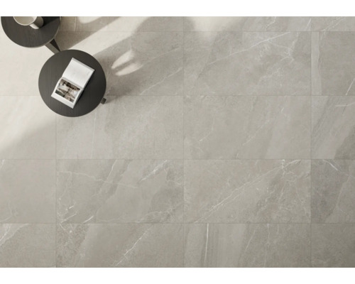 Helle Bodenfliesen mit Marmoroptik verlegt, mit Tisch und Buch.