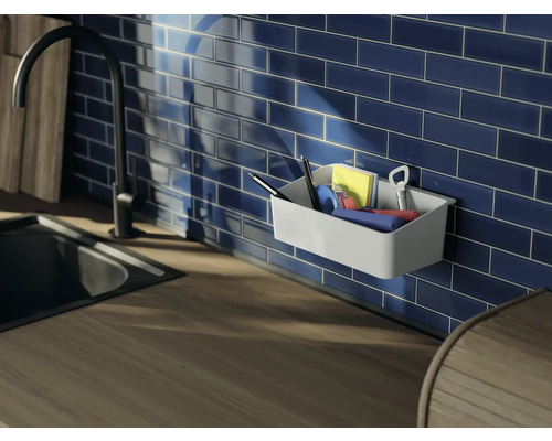 Organisateur mural avec fournitures de bureau sur un mur carrelé bleu au-dessus d''un comptoir de cuisine