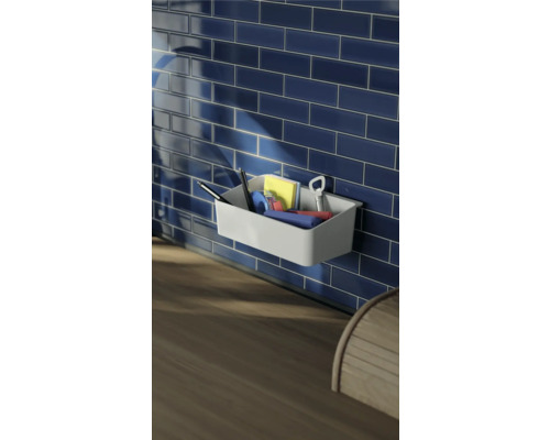 Étagère murale avec stylos, notes et ouvre-bouteille devant des carreaux bleus