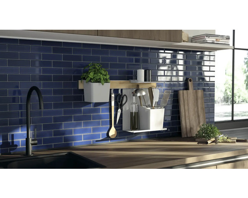 Scène de cuisine avec évier, robinet, mur de carreaux et ustensiles de cuisine