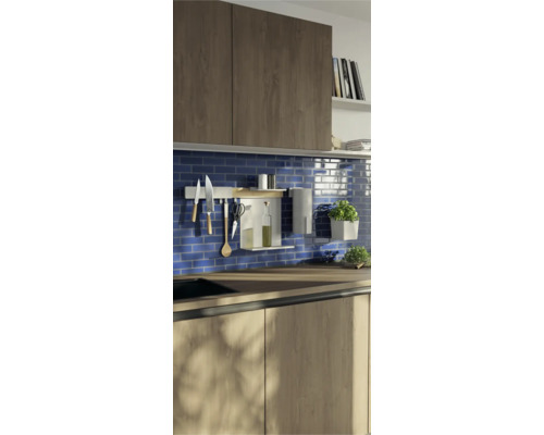 Scène de cuisine avec des ustensiles de cuisine sur une barre de suspension et des herbes aromatiques en pot