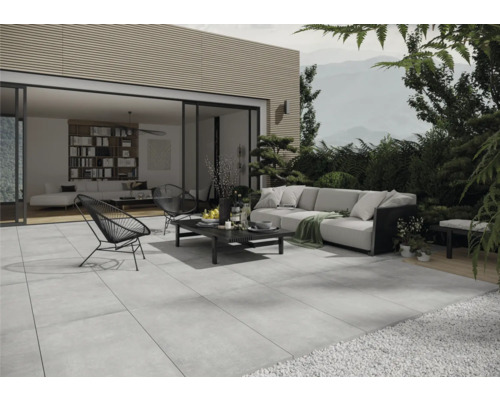 Terrasse avec dalles en pierre grises, coin salon et vue sur un salon