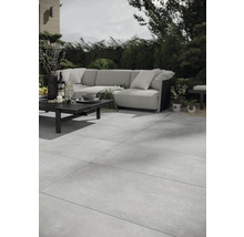 Terrasse mit grossformatigen Steinzeugfliesen, Sofagarnitur und Tisch im Aussenbereich.
