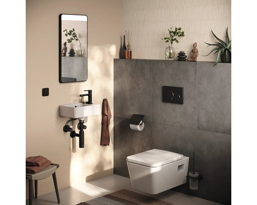 Badezimmer mit wandhängendem WC, Waschtisch, Spiegel und Accessoires