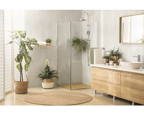 Helles Badezimmer mit Dusche, Waschtisch, Spiegel und Pflanzen für eine freundliche Atmosphäre.