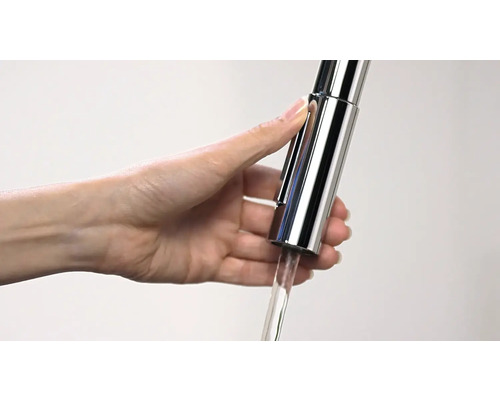 Frauenhand bedient einen Wasserhahn